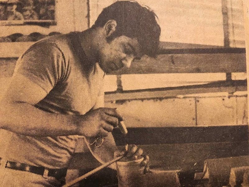Nunzio Santore at a workbench in 1973, working on a shell by hand, from a newspaper print